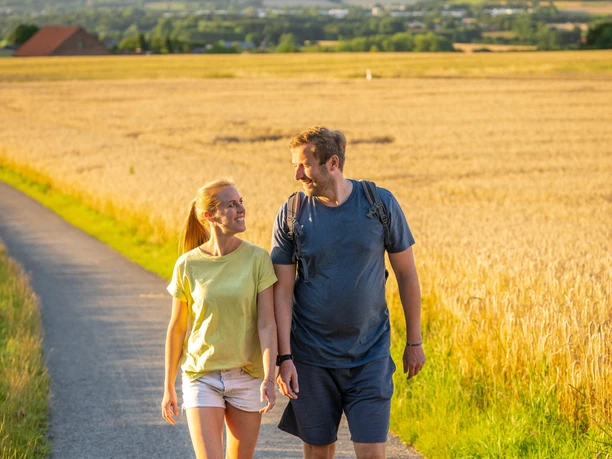 Wanderndes Paar auf Feldweg bei Bad Salzuflen im Abendlicht