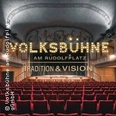 Blick in den Saal der Volksbühne mit rotem Gestühl und beleuchtetem Bühnen-Schriftzug