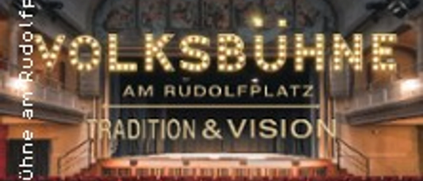 Blick in den Saal der Volksbühne mit rotem Gestühl und beleuchtetem Bühnen-Schriftzug