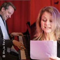 Ein Mann am Klavier und eine Frau, die ein Blatt hält, vor rotem Hintergrund.