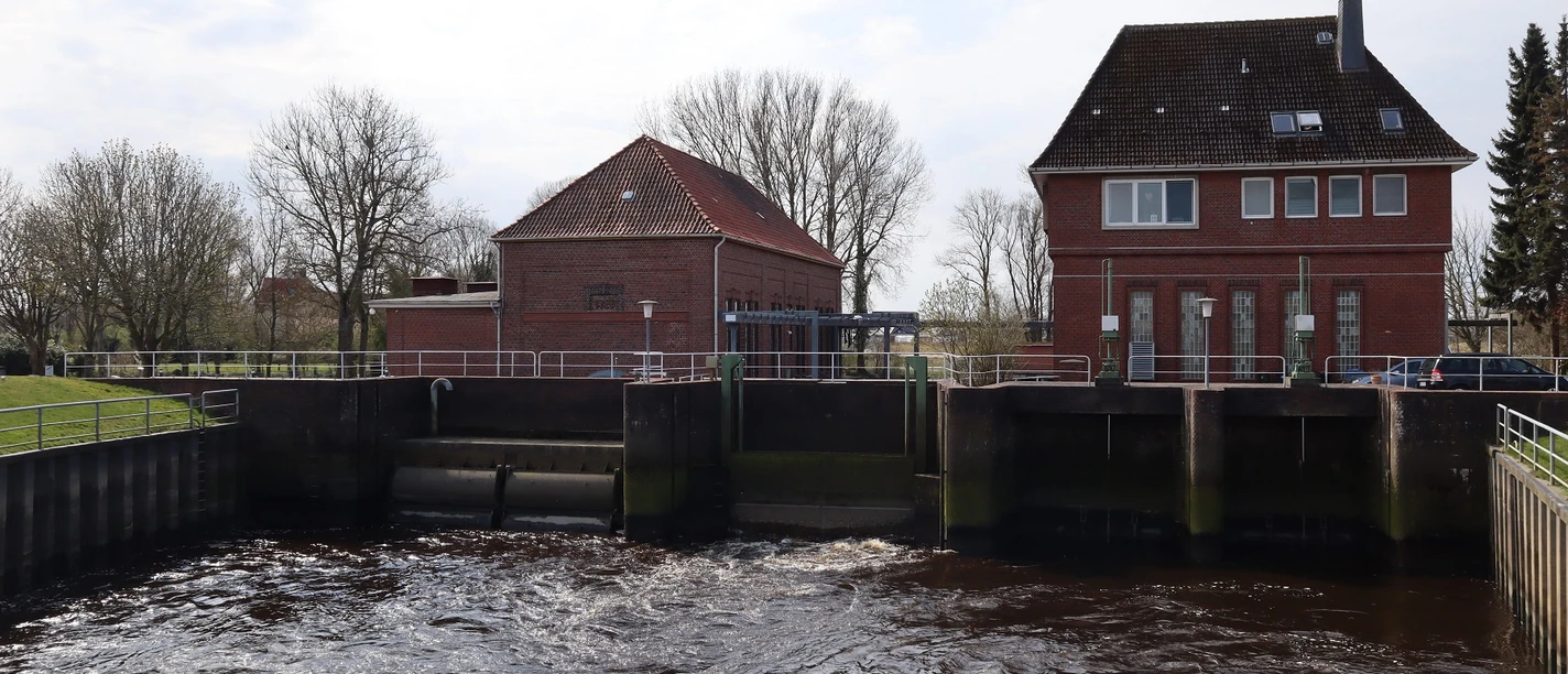 Schöpfwerk Backsteinbauten des Schöpfwerks Otterndorf mit Schleusenanlage und vorbeiströmendem Wasser.