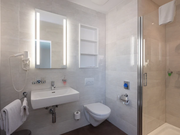 Hotel Post Willisau Modernes Badezimmer im Gasthaus Post Willisau mit Dusche Waschbecken und hellen Fliesen