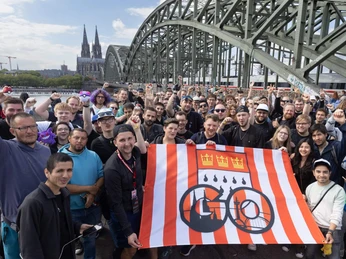Pokémon GO Community Eine große Gruppe von Menschen posiert vor der Hohenzollern Brücke und Kölner Dom.A large group of people pose in front of the Hohenzollern Bridge and Cologne Cathedral.