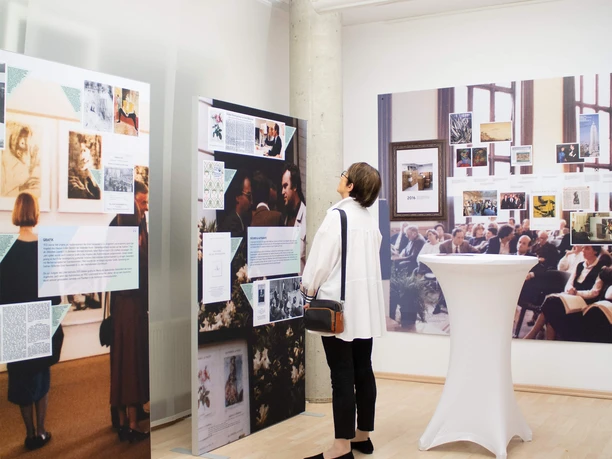 Vernissage 2024 A person at a vernissage at ZADIK looks at information boards made from image and text material created for the exhibition at ZADIK.
