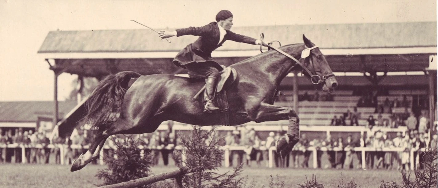 Altes Foto eines Reiters auf seinem Pferd beim Sprung über ein Hindernis auf dem CHIO Gelände in Aachen.