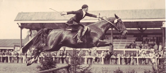 100 Jahre CHIO Aachen_Fotoausstellung (c) Centre Charlemagne.jpg Altes Foto eines Reiters auf seinem Pferd beim Sprung über ein Hindernis auf dem CHIO Gelände in Aachen.