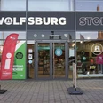 Außenaufnahme Wolfsburg Store inkl. Tourist-Information Glasfassade des Wolfsburg Store mit Eingang zur Tourist-Information und Aufsteller im Vordergrund