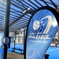 Hall of Padel Innenansicht einer modernen Padelhalle mit blauem Spielfeld und spielenden Personen im Hintergrund