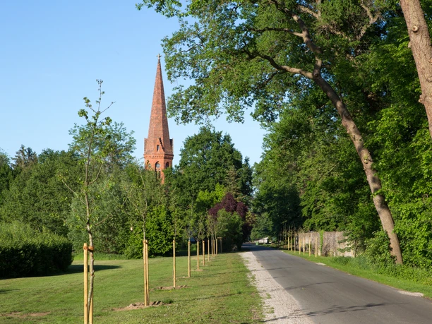 Ev.-luth. St.-Johannis-Kirche Arenshorst Ev.-luth. St.-Johannis-Kirche der St.-Johannis-Kirchengemeinde Arenshorst, mit markantem Kirchturm, umgeben von Grünflächen und einer ruhigen Allee.