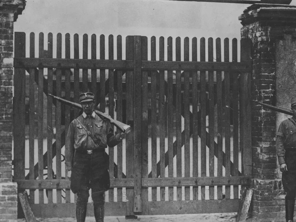 Auftakt des Terrors.png 1 /4 SA-Wache vor dem Tor des KZ Oranienburg, Juni 1933 (Propagandaaufnahme) © SZ-Photo, 00007276, Foto: Scherl