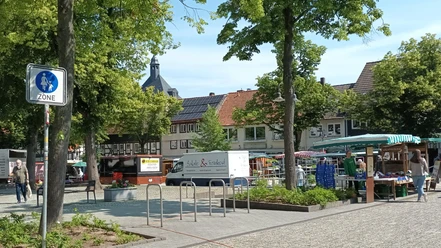Wochenmarkt auf dem Marktplatz in Salzgitter-Bad mit Ständen, Besuchern und Fachwerkhäusern.