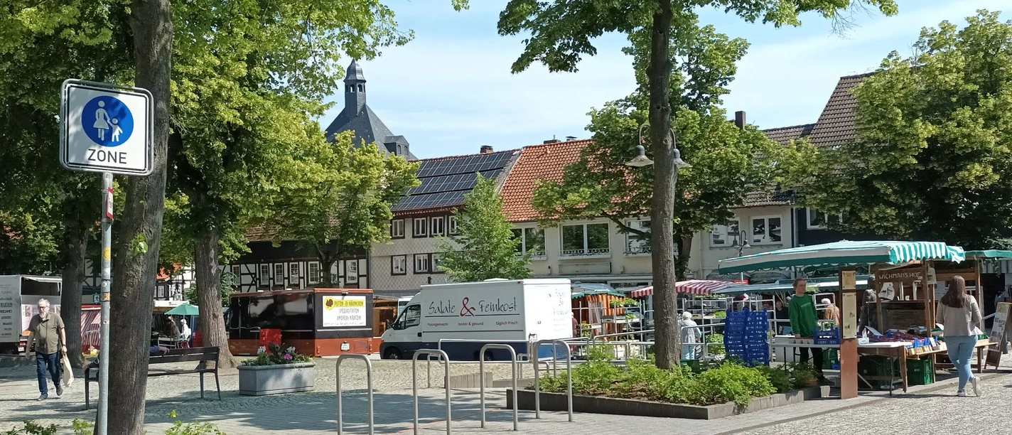 Wochenmarkt auf dem Marktplatz in Salzgitter-Bad mit Ständen, Besuchern und Fachwerkhäusern.