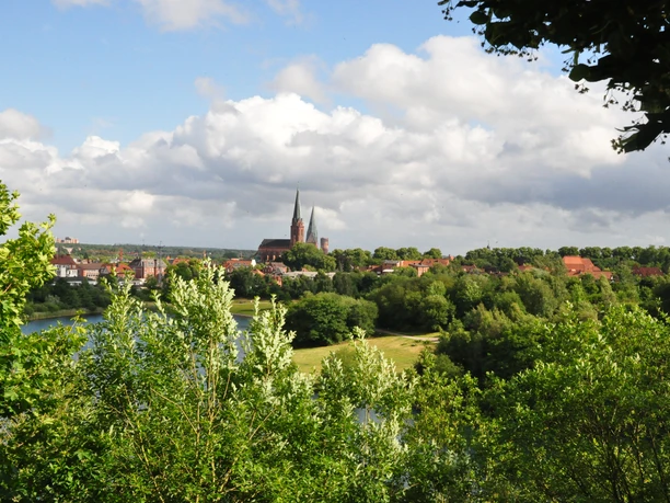 2321_Kreideberg_CC BY-SA_©-Lüneburg Marketing GmbH Mathias Schneider.jpg Blick durch grüne Bäume über den Kreidebergsee auf die Kirchtürme der Lüneburger Altstadt.