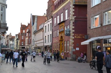 191459585_Bäckerstraße_CC BY-SA_©Lüneburg Marketing GmbHMerle-Marie Matthießen.jpg Passanten in der Lüneburger Fußgängerzone vor der historischen Alten Raths-Apotheke.