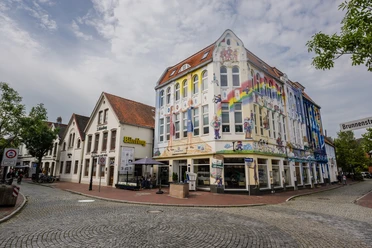 20240822- FeuerQuell Fotografie - 15.jpg Bunte Fassaden mit Wandmalerei am Café J. Bünting Coloniale in der Altstadt von Leer.