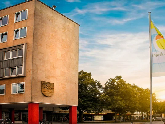 Rathaus Espelkamp Rathaus Espelkamp mit heller Steinfassade, Fensterreihen und Espelkamp-Fahnen auf dem Vorplatz.