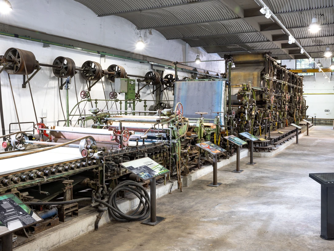 Papiermaschine Historische Papiermaschine im LVR-Industriemuseum mit Walzen, Bändern und Info-Tafeln.