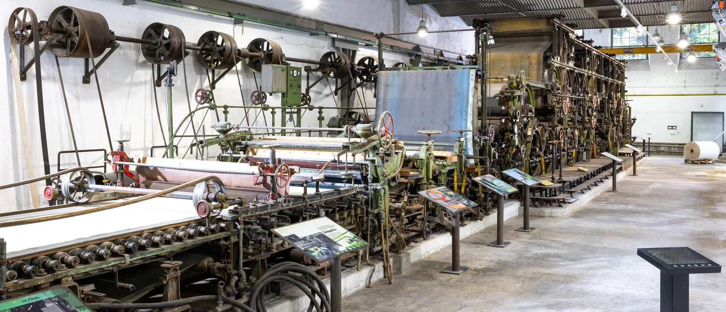 Papiermaschine Historische Papiermaschine im LVR-Industriemuseum mit Walzen, Bändern und Info-Tafeln.