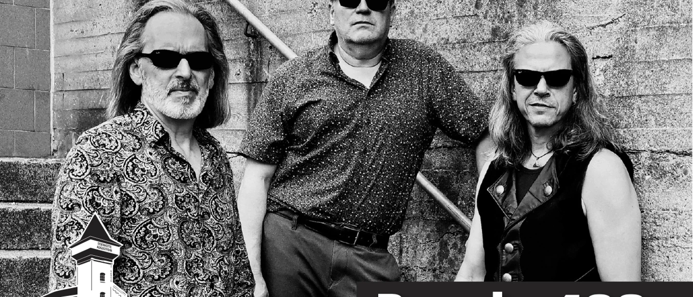 Anzeige Band 409_2026.jpg Drei Musiker mit Sonnenbrillen posieren lässig vor einer Betonwand, darunter Schriftzug Band 409.