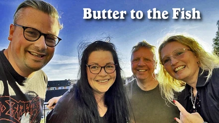 Butter to the Fish.jpg Vier Bandmitglieder von Butter to the Fish lächelnd im Freien unter blauem Himmel.