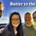 Butter to the Fish.jpg Vier Bandmitglieder von Butter to the Fish lächelnd im Freien unter blauem Himmel.