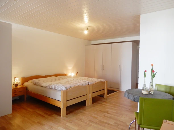 Ferienwohnung Roos Ohmstal_Schlafzimmer.jpg Helles Schlafzimmer der Ferienwohnung Roos Ohmstal mit Doppelbett Kleiderschrank und Holzboden
