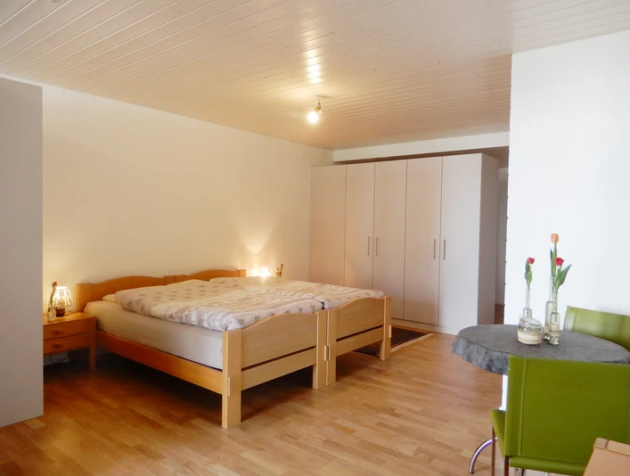 Ferienwohnung Roos Ohmstal_Schlafzimmer.jpg Helles Schlafzimmer der Ferienwohnung Roos Ohmstal mit Doppelbett Kleiderschrank und Holzboden