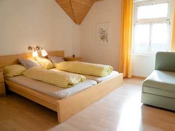 Ferienwohnungen Napf Chäsi Luthern Helles Schlafzimmer der Ferienwohnung Napf Chäsi mit Doppelbett und Sitzmöglichkeit