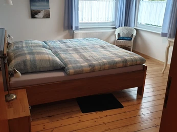 fewo_lebensfreude_schlafzimmer1.jpg Schlafzimmer mit Holzfußboden und Doppelbett aus Holz