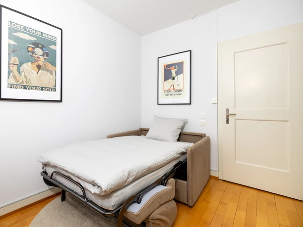 Zusatzbett im Wohnbereich der Ferienwohnung Villa im Park in Nebikon mit ausziehbarem Sofa und Wanddekoration