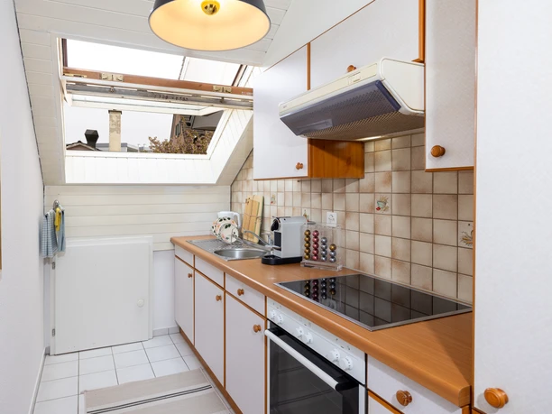 Helle Küche der Ferienwohnung Roof Top in Willisau mit Kochherd, Backofen und Dachfenster