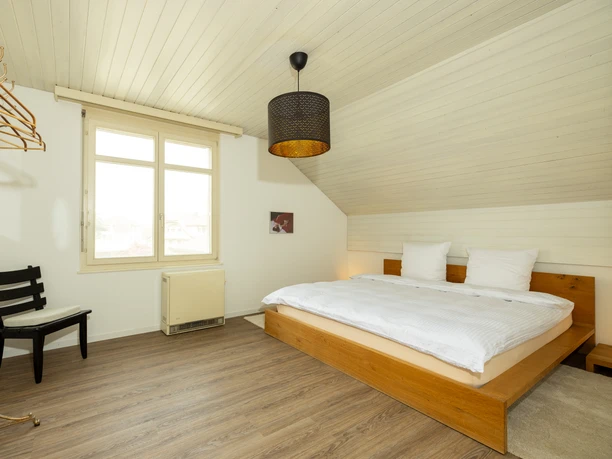 Ferienwohnung Roof Top Willisau Gemütliches Schlafzimmer der Ferienwohnung Roof Top in Willisau mit Doppelbett und hellem Dachzimmer