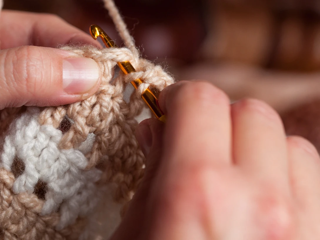 AdobeStock_296178935-2560x1707.jpg Zwei Hände mit Häkel-Nadel