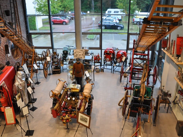 3204_Lange Nacht der Museen_Feuerwehrmuseum_CC BY-SA_©-Lüneburg Marketing GmbH.jpg Helle Museumshalle mit historischen Feuerwehrwagen, hölzernen Leitern, Pumpen und alten Uniformen.