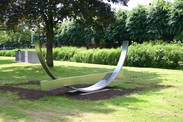 Skulpturen - Gezeiten XVII Moderne Edelstahlskulptur mit geschwungenen Formen auf grüner Wiese im Skulpturenpark Otterndorf