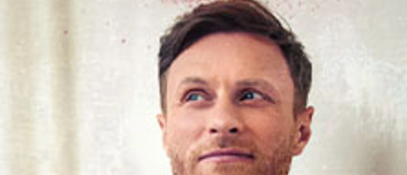 Porträt eines Mannes vor hellem Hintergrund mit rotem Schriftzug Tour 2026