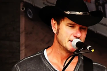 Santa Gerald Klöpfer, Pressefoto1, 2024-2560x1707.jpg Ein Mann mit Cowboyhut singt in ein Mikrofon.