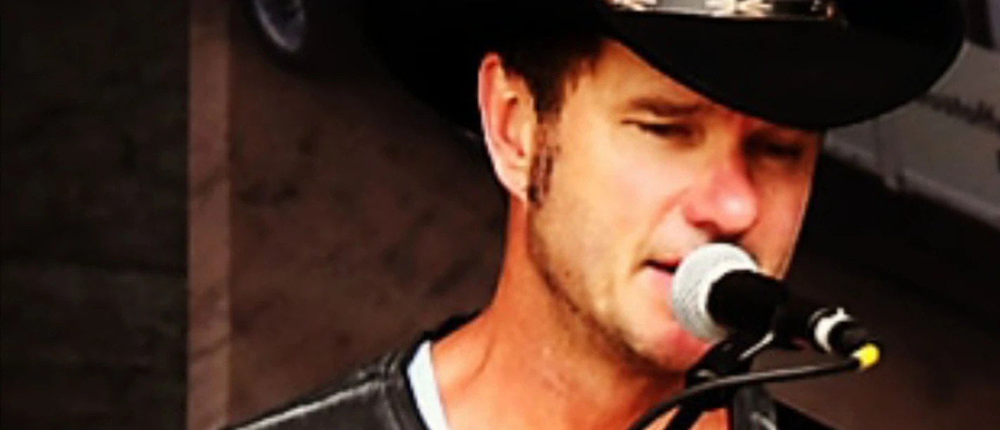 Santa Gerald Klöpfer, Pressefoto1, 2024-2560x1707.jpg Ein Mann mit Cowboyhut singt in ein Mikrofon.