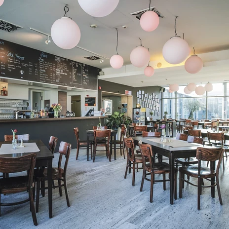 LIDO®Thomas Kubiczek.jpg Helles Restaurant mit Holztischen und runden Lampen im LIDO.