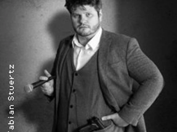 Mann im Anzug hält Mikrofon und Aufnahmegerät in einem monochromen Porträt