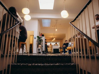 Aufgang Treppenaufgang mit Personen und Loungebereich im Hintergrund