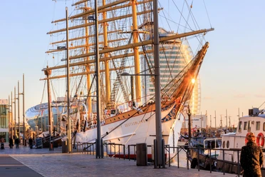 Schulschiff Deutschland an ihrem Liegeplatz im Neuen Hafen (c) Jörg Sarbach_Erlebnis Bremerhaven.jpg Das historische Segelschiff Schulschiff Deutschland liegt im Sonnenlicht am Kai des Neuen Hafens.