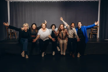Teambuilding Improtheater Group of people posing on stage