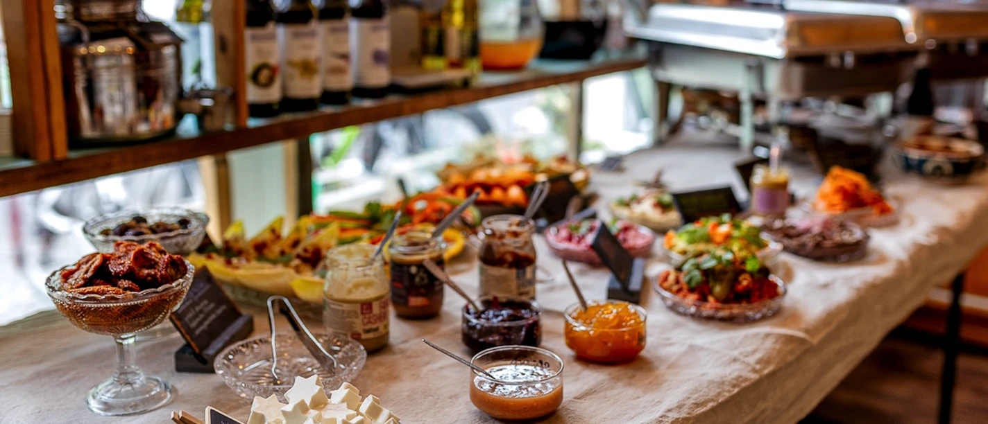 Brunch Brunch-Bufett mit Aufstrichen, Aufschnitten, Obst, Gemüse und Warmhaltebehältern