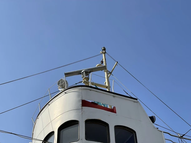 Steuerhaus des Museumsschleppers Stier mit Radarantenne und klarer Sicht auf den blauen Himmel.