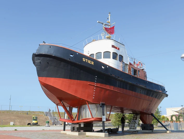 Stier_Wolfhard_Scheer (c) Wolfhard Scheer_DSM_WEB.jpg Historischer Schlepper Stier aufgebockt am Museumshafen Bremerhaven unter blauem Himmel.