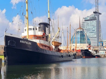 Seefalke Museumshafen 20220909_124823 (c) Dagmar Brandenburg_Erlebnis Bremerhaven_WEB.jpg Historischer Hochseeschlepper Seefalke im Museumshafen Bremerhaven vor moderner Stadtkulisse
