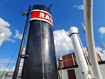 Rau IX 20210928_153304 (c) Dagmar Brandenburg_Erlebnis Bremerhaven_WEB.jpg Schornstein des Museumsschleppers Rau IX mit rotem Schriftzug vor blauem Himmel in Bremerhaven