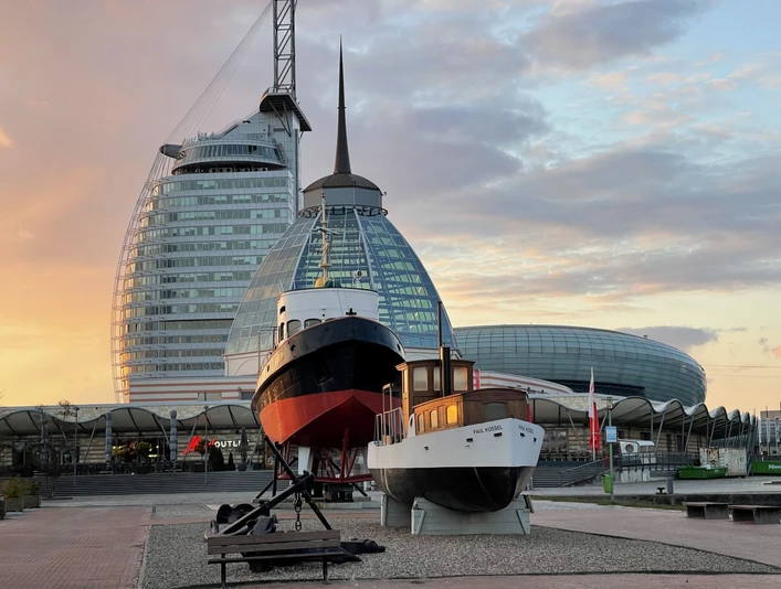 Paul Kossel Deutsches Schifffahrtsmusem IMG_1250 (c) Vanessa Wilke_Erlebnis Bremerhaven_WEB.jpg Zwei historische Schiffe vor moderner Architektur im Museumshafen Bremerhaven bei Abendlicht.