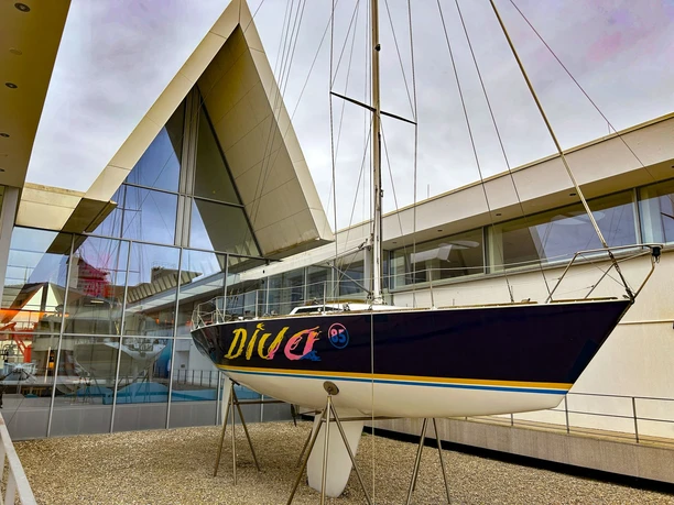 Diva IMG_5935 (c) Tanja Mehl_Erlebnis Bremerhaven_WEB.jpg Segelyacht „Diva“ aufgeständert vor moderner Glasfassade im Museumshafen des Deutschen Schifffahrtsmuseums.